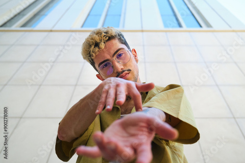 Low angle photo of a young man with dyed hair is dancing contemporary dance at street