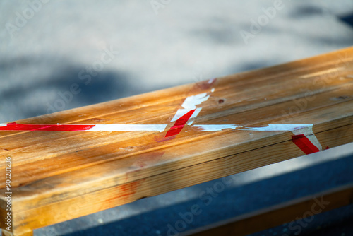 bench marked by the imprint of a prohibitive tape, symbolizing the lingering effects of pandemic restrictions on public spaces and social interactions