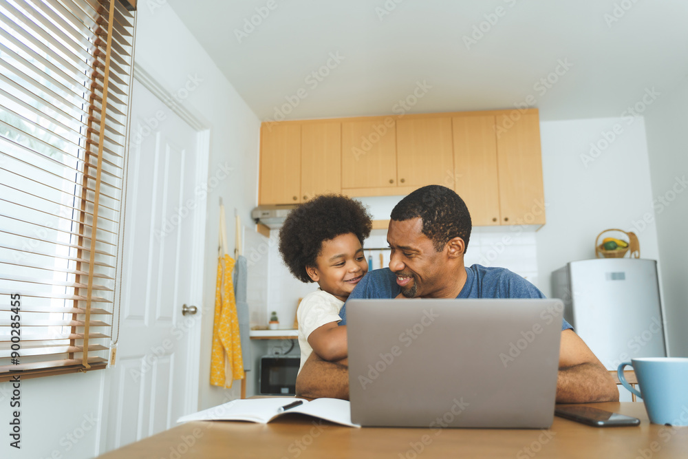Black African American Father and child bonding while using a laptop at home kitchen table. Casual home lifestyle. Family bonding and remote work concept. Black African American Father and child bonding while using a laptop at home kitchen table. Casual home lifestyle. Family bonding and remote work concept.