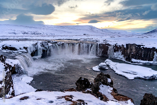 Beautiful landscape at frozen Godafoss waterfall at sunset in winter, Iceland.