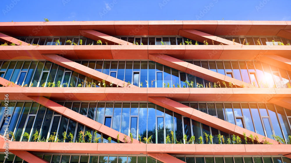 Modern office building with glass facade on a clear sky background. Transparent glass wall of office building. Modern office building with glass facade on a clear sky background. Transparent glass wall of office building.