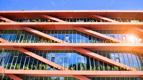 Foto Modern office building with glass facade on a clear sky background