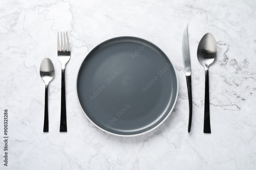 Stylish cutlery and plate on white marble table, flat lay Stylish cutlery and plate on white marble table, flat lay