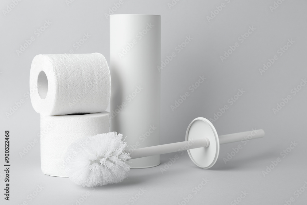 Obraz premium Toilet brush, holder and rolls of paper on white background