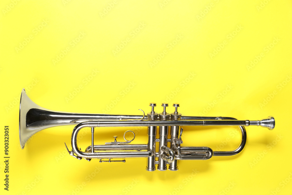 Obraz premium One trumpet on yellow background, top view. Space for text