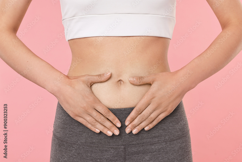Healthy digestion. Woman making heart shape with hands near her belly on pink background, closeup Healthy digestion. Woman making heart shape with hands near her belly on pink background, closeup