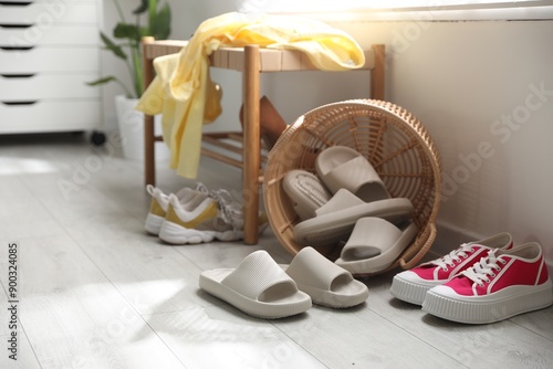 Basket with slippers for guests and sneakers in entryway at home