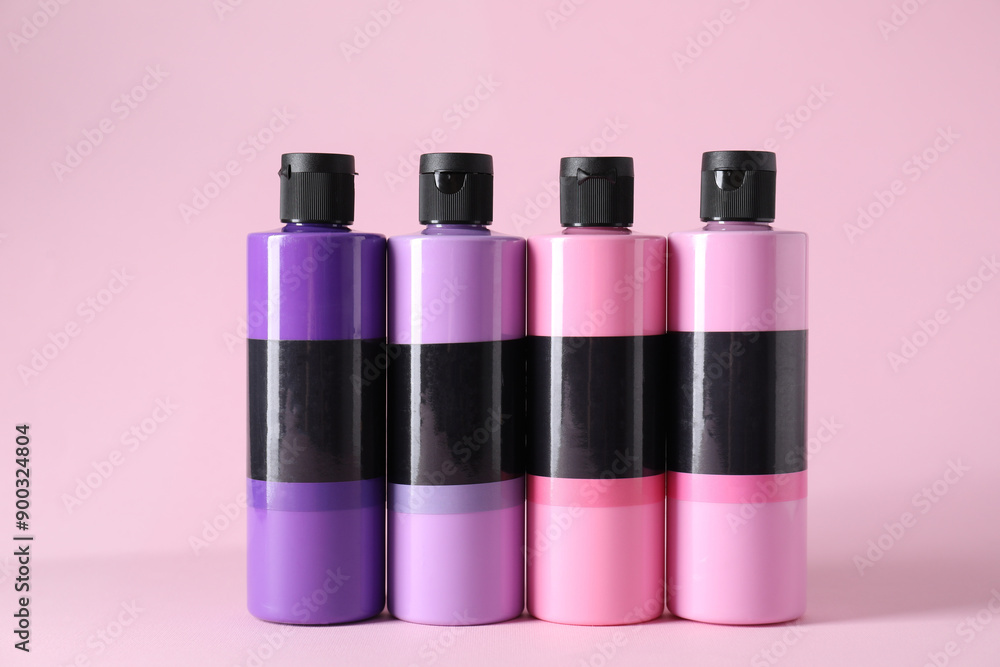 Acrylic paints of different colors on pink background