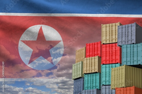 North Korea flag and big stack of shipping cargo containers in docks with sky background close up photo