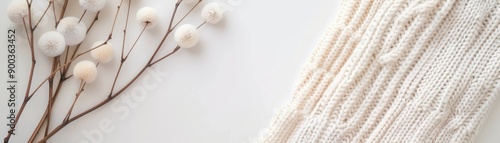 A white blanket is on a white background with a bunch of white flowers