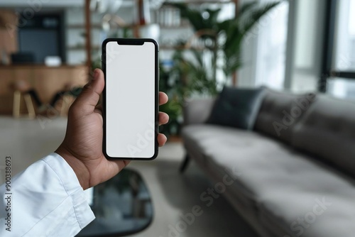 Beautiful close-up of a doctor's hand elegantly displaying a blank white mobile screen in a medical workplace. © Yuliia