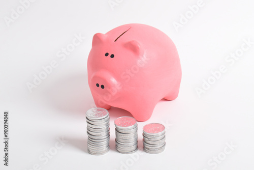 Pink piggy bank and stack of coins isolated on white background. Investment budget savings wealth business retirement, finance, money, banking concept. copy space