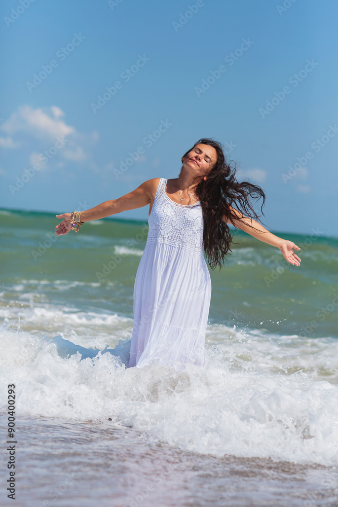 Fototapeta premium Mature woman finds peace and relaxation by the ocean, her carefree demeanor and windblown hair reflecting the bliss of seaside living.