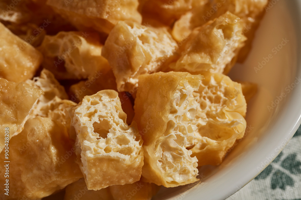 A bowl of fried, sliced tofu puffs, a classic Asian ingredient A bowl of fried, sliced tofu puffs, a classic Asian ingredient