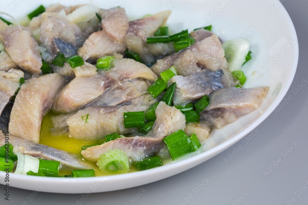 Sliced pickled atlantic herring with chopped green onion close-up Sliced pickled atlantic herring with chopped green onion close-up