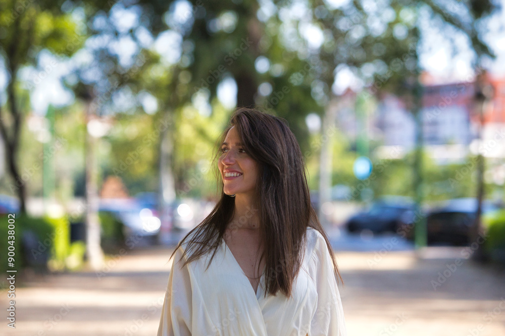 young and beautiful latin woman, walking down a central street in the city of Seville, the woman looks to the side and smiles while on holiday in Spain. Travel and holiday concept. young and beautiful latin woman, walking down a central street in the city of Seville, the woman looks to the side and smiles while on holiday in Spain. Travel and holiday concept.