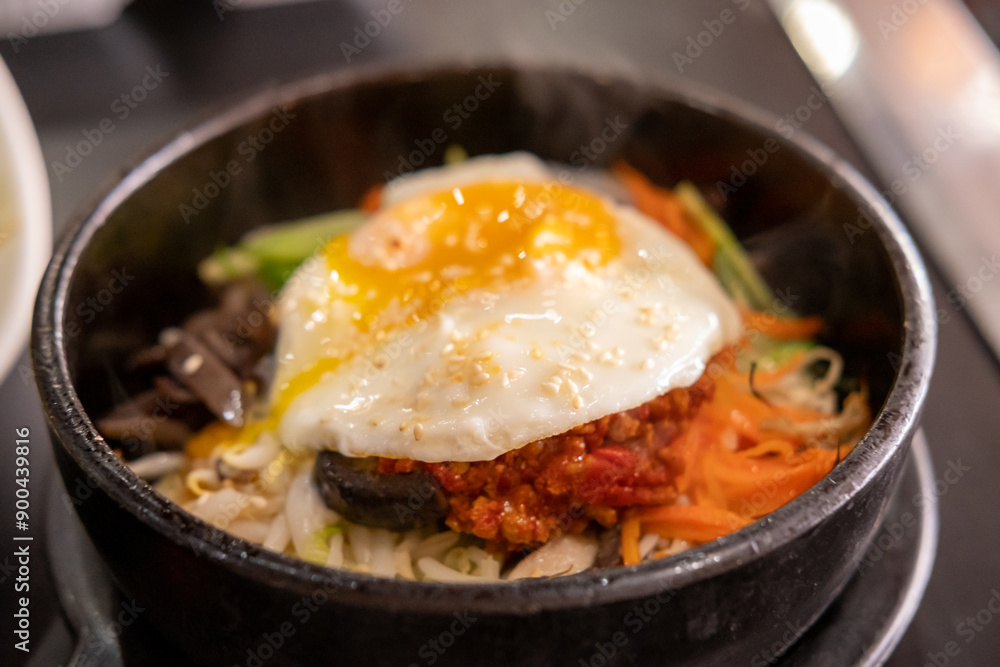 Bibimbap, a Korean rice dish. It is cooked rice mixed with namul, gochujang, egg and meat. Bibimbap, a Korean rice dish. It is cooked rice mixed with namul, gochujang, egg and meat.