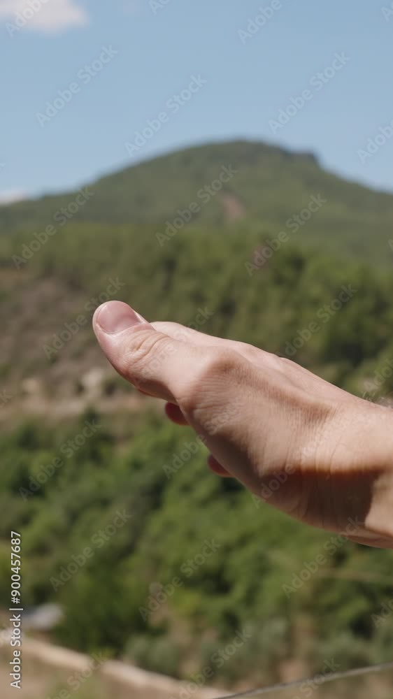 Vertical video. A Hand Reaching Out the Window of a Car, Feeling the Breeze. The Side Mirror Reflects the Scene, While Mountains and a Clear Sky Create a Scenic Backdrop. This Captures a Simple Joyful Vertical video. A Hand Reaching Out the Window of a Car, Feeling the Breeze. The Side Mirror Reflects the Scene, While Mountains and a Clear Sky Create a Scenic Backdrop. This Captures a Simple Joyful