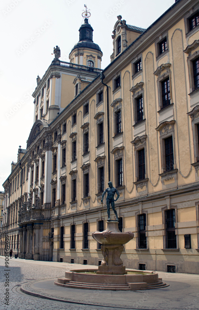 Obraz premium The University of Wrocław photographed as a background to the fountain in the foreground on a sunny day