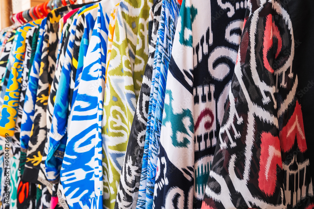 Obraz premium traditional indian dresses made of silk fabric with a bright colorful pattern at oriental bazaar in India close-up
