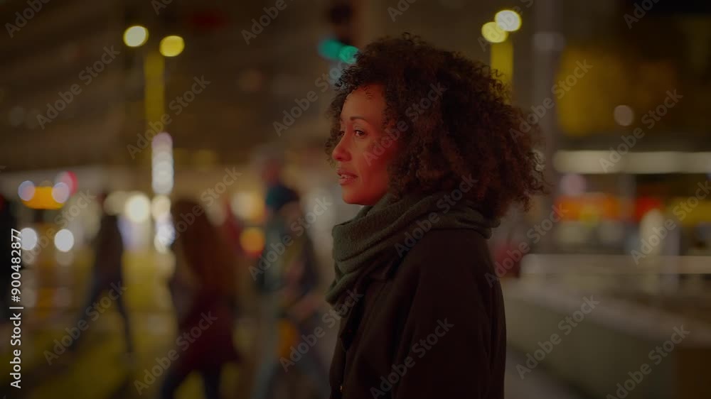 A woman on a busy city street at night with blurred lights around in the urban atmosphere A woman on a busy city street at night with blurred lights around in the urban atmosphere