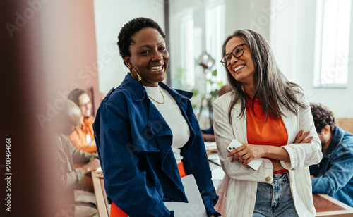 Fotografie Creative co-working environment with diverse women colleagues chatting and laugh