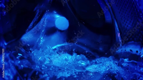 Close-up of a washing machine drum spinning with water.