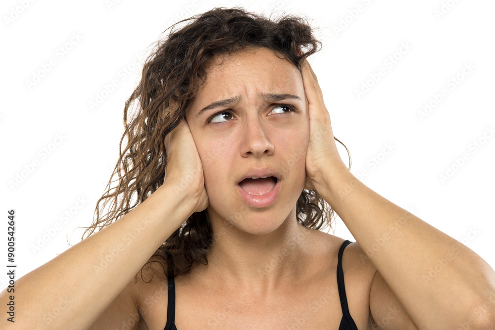 Exhausted young woman. Pain, stress loud sound and despair concept. White studio background Exhausted young woman. Pain, stress loud sound and despair concept. White studio background