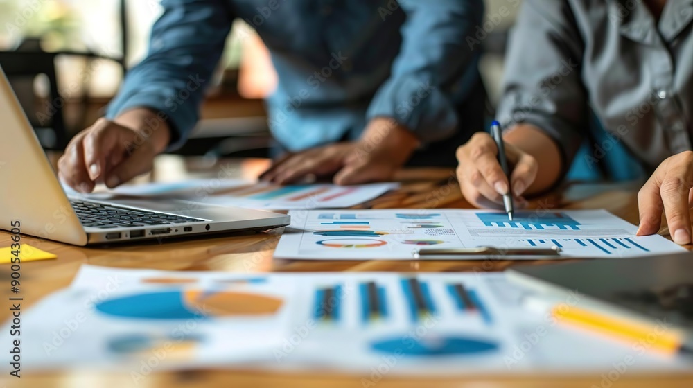 Business People Analyzing Charts and Graphs on a Wooden Desk - Photo