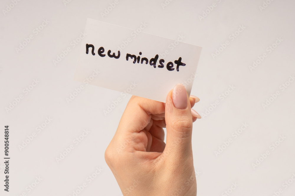 New mindset - new result  text on a card in a woman hand.