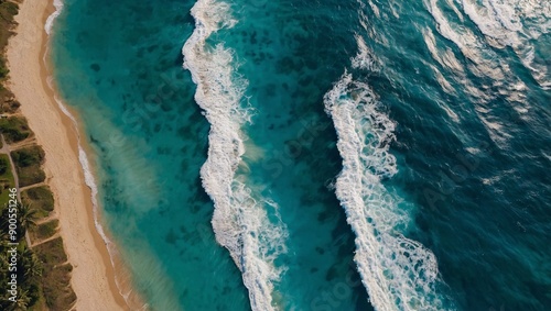 Summer beach top-down view with blue water waves and sun reflections, high contrast