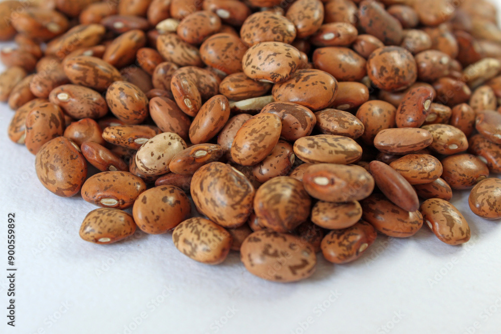 Vibrant image of pinto beans arranged on white backdrop, showcasing rich brown and beige hues. Nutritious, versatile, and visually striking Vibrant image of pinto beans arranged on white backdrop, showcasing rich brown and beige hues. Nutritious, versatile, and visually striking