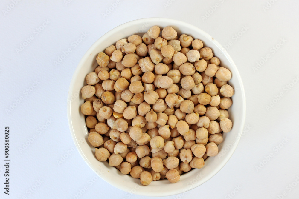 Overflowing white bowl of chickpeas on clean background, ideal for vegan diets. Rich in protein and fiber, these legumes are healthy and organic Overflowing white bowl of chickpeas on clean background, ideal for vegan diets. Rich in protein and fiber, these legumes are healthy and organic