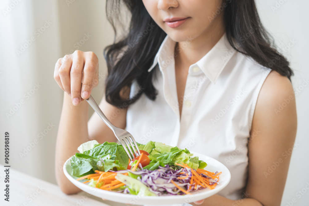 Diet in bored face, unhappy beautiful asian young woman, girl on dieting, holding fork at tomato on salad plate, dislike or tired with eat fresh vegetables. Nutrition of clean, healthy food good taste Diet in bored face, unhappy beautiful asian young woman, girl on dieting, holding fork at tomato on salad plate, dislike or tired with eat fresh vegetables. Nutrition of clean, healthy food good taste