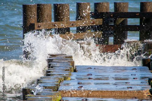 Am Strand. Wasser trifft auf einen kleinen Holzsteg photo