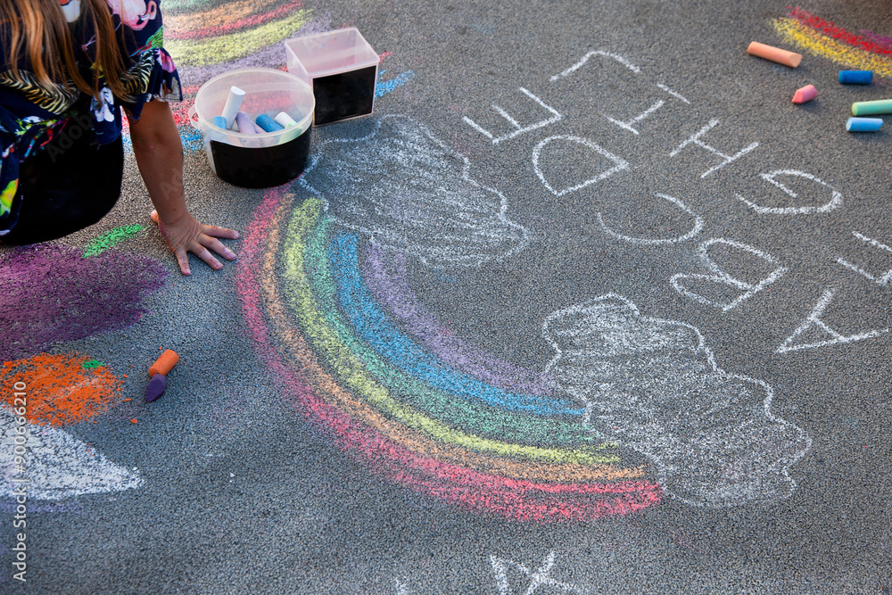 Children draw a rainbow on the asphalt with colored chalk. Sidewalk ...