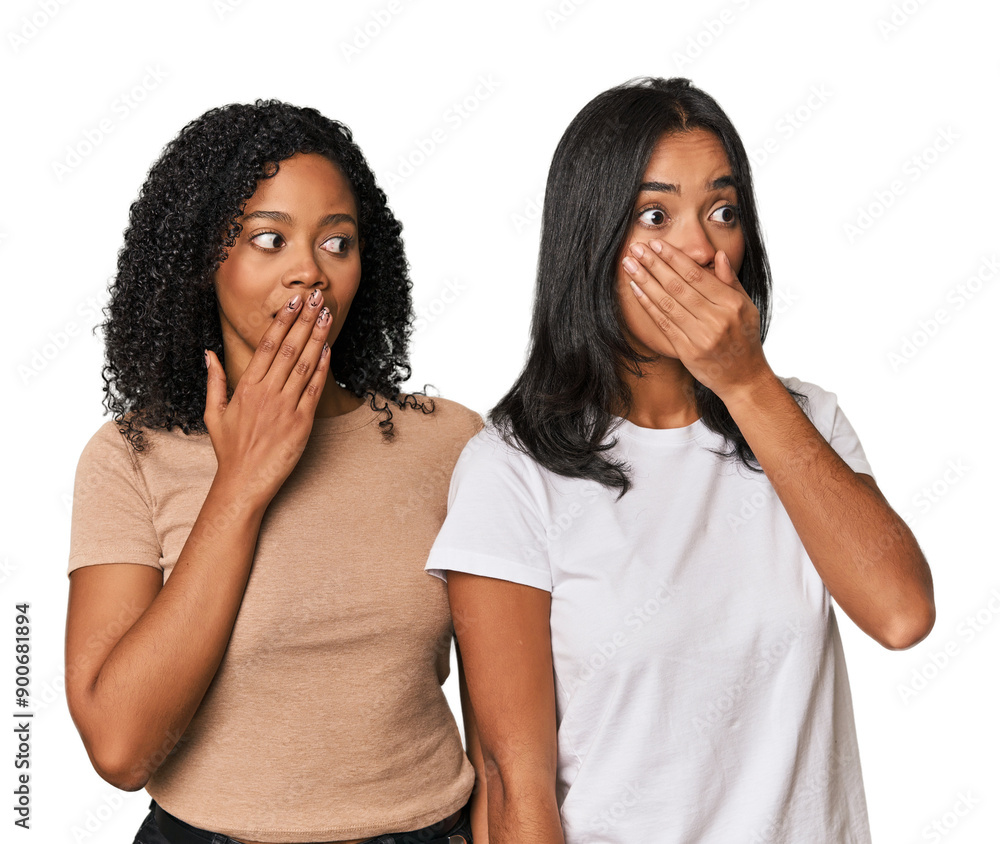 Young Latin friends in studio thoughtful looking to a copy space covering mouth with hand. Young Latin friends in studio thoughtful looking to a copy space covering mouth with hand.