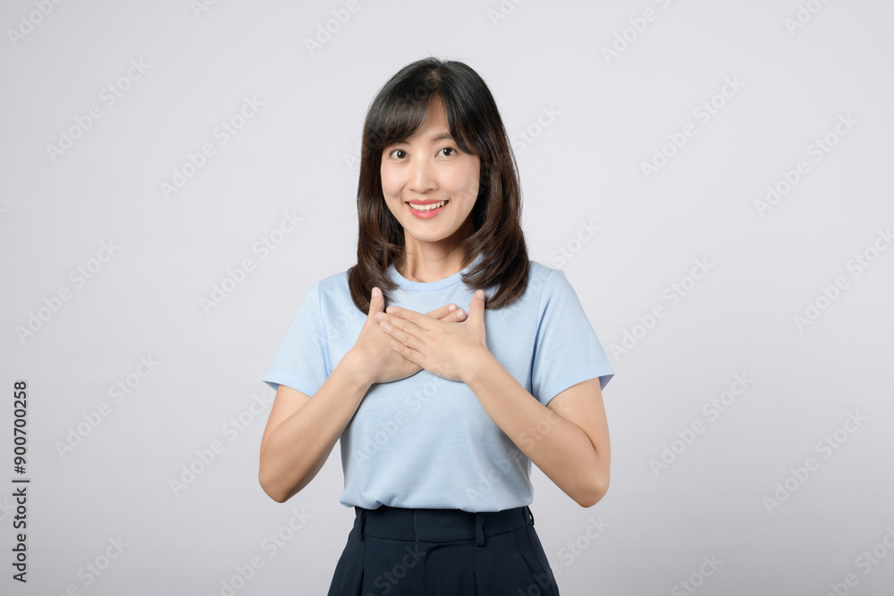 Satisfied feeling. young asian woman happy smile dressed in blue clothes showing hands touching her chest in proud and thankful emotional feeling isolated on white studio background. Satisfied feeling. young asian woman happy smile dressed in blue clothes showing hands touching her chest in proud and thankful emotional feeling isolated on white studio background.
