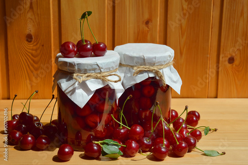 cherry jam in glass jars, sweet confiture, homemade pastry preparations made from berries. ripe juicy berries. background for the design.