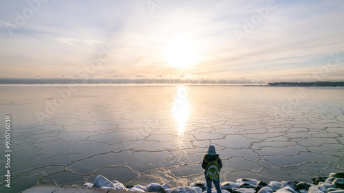 A lonely girl at the sea side in Helsinki Finland on a cold winter day
