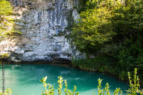 Tableau sur toile A bright blue lake among the steep rocky shores in Abkhazia on a clear sunny sum