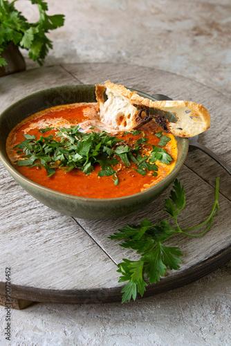 bowl with cream soup of baked bell peppers and tomatoes on a light table