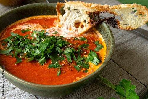 bowl with creamy baked bell pepper soup on the table