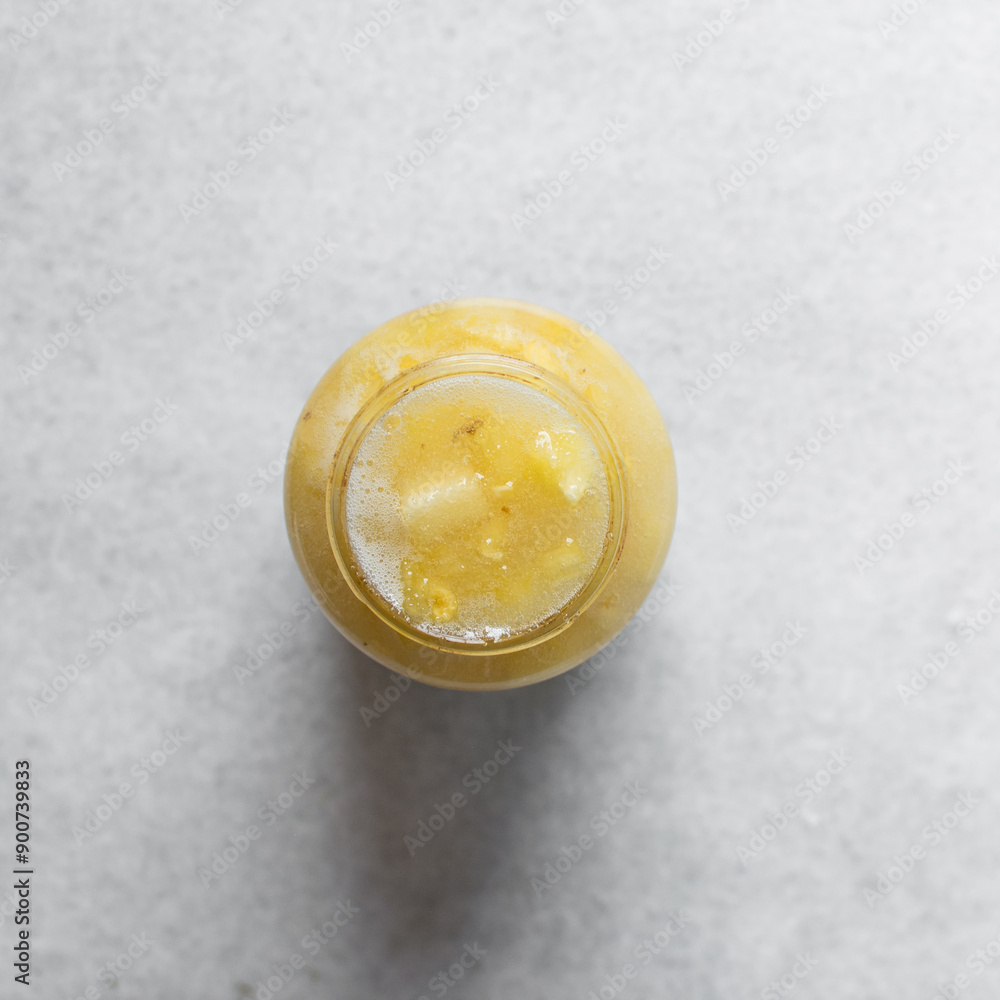 Overhead view of pineapple cheong in a glass jar on a white background, top view of korean pineapple cheong in a transparent jar, pineapple in sugar syrup, process of making pineapple cheong Overhead view of pineapple cheong in a glass jar on a white background, top view of korean pineapple cheong in a transparent jar, pineapple in sugar syrup, process of making pineapple cheong