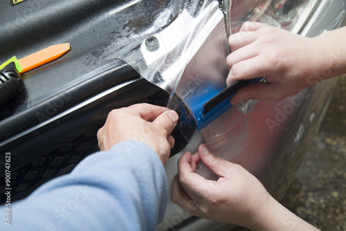 Polishing the old headlight on the car and installing a protective film.