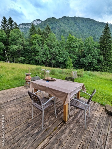 A table and chairs set in a relaxing area of the Dolomites, surrounded by natural beauty. This peaceful spot is perfect for unwinding and enjoying the outdoors