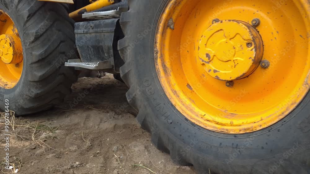 Heavy Machinery Operating in Construction Area During Daytime With Focus on Tire Details Heavy Machinery Operating in Construction Area During Daytime With Focus on Tire Details