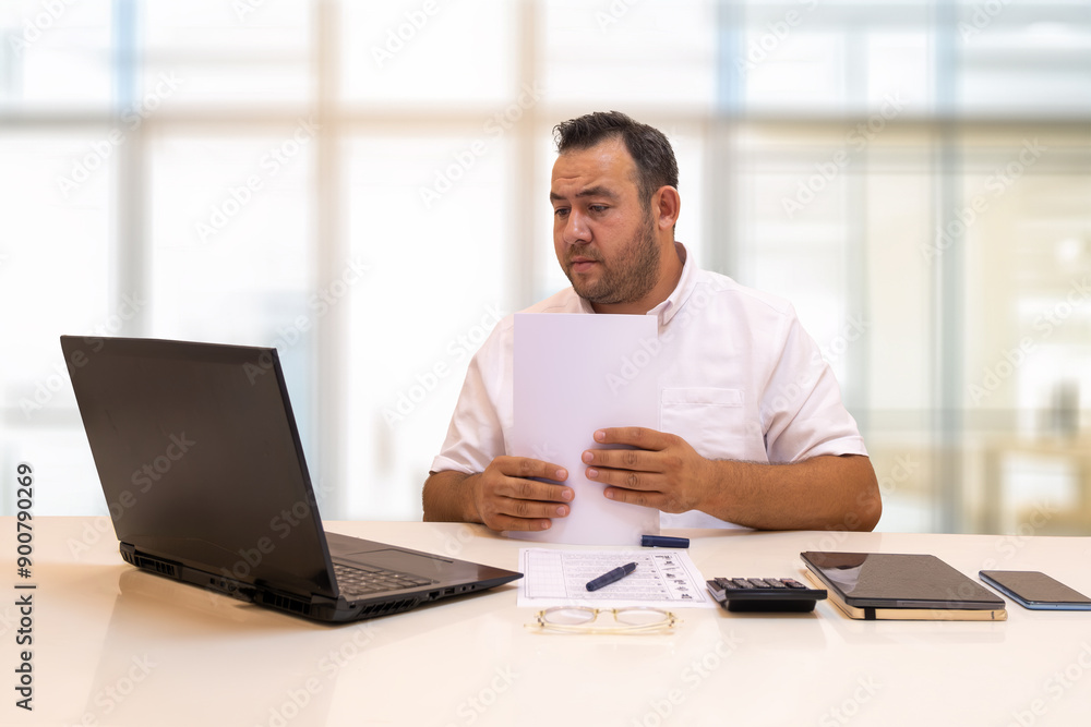 A businessman who has finished going through the files in his hand. He is organizing the files while looking at the computer screen. A businessman who has finished going through the files in his hand. He is organizing the files while looking at the computer screen.
