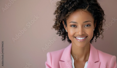 Woman Smiling in Pink Blazer Against a Blue Wall