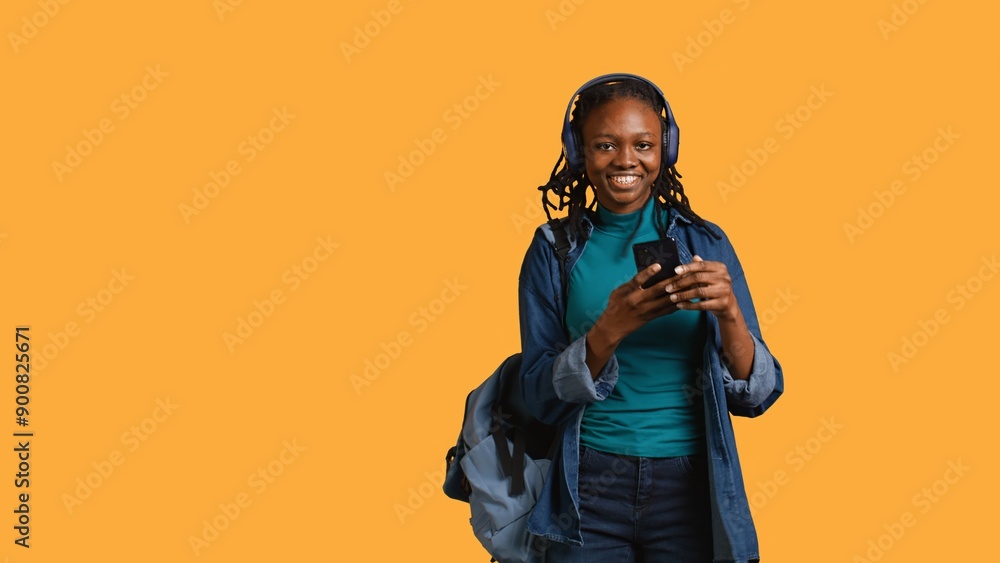 Happy person having fun, dancing on rhythm, enjoying songs during leisure time. Cheerful BIPOC woman doing funky movements on music playing on headphones, studio background, camera B Happy person having fun, dancing on rhythm, enjoying songs during leisure time. Cheerful BIPOC woman doing funky movements on music playing on headphones, studio background, camera B